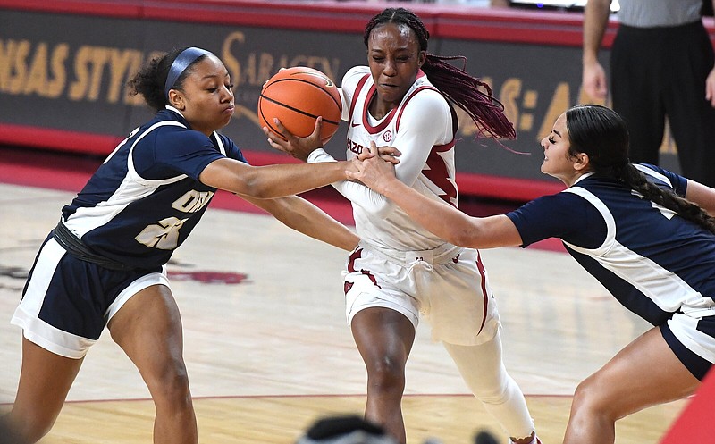 Arkansasâ€™ Samara Spencer drives to the basket under pressure from Oral Robertsâ€™ Talia Pogi (left) and Hannah Cooper Sunday Dec. 4, 2023 at Bud Walton Arena in Fayetteville. The Lady Razorbacks won 92-58. Visit nwaonline.com/photo for today's photo gallery.   (NWA Democrat-Gazette/J.T. Wampler).