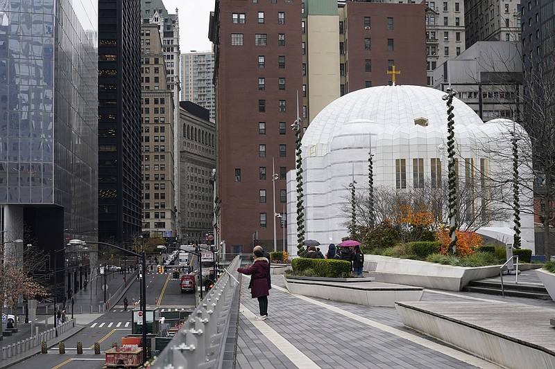 St. Nicholas Greek Orthodox Church, right, sits next to ground zero in New York, Tuesday, Dec. 6, 2022. After a rebuilding process that lasted more than two decades, the Greek Orthodox church that was destroyed in the Sept. 11 attacks has reopened at the World Trade Center site. The St. Nicholas Greek Orthodox Church and National Shrine, designed by architect Santiago Calatrava, now overlooks the Trade Center memorial pools from an elevated park. (AP Photo/Seth Wenig)