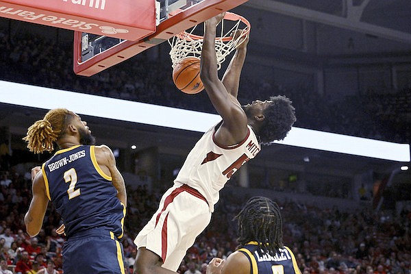 Arkansas forward Makhi Mitchell dunks the ball over UNC Greensboro forward Mikeal Brown-Jones (2) during the second half of an NCAA college basketball game, Tuesday, Dec. 6, 2022, in Fayetteville. (AP Photo/Michael Woods)