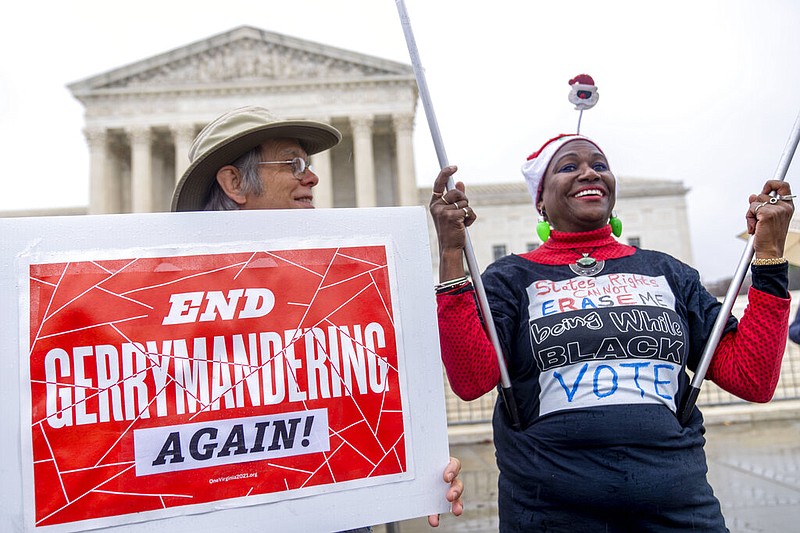 Michael Martin of Springfield, Va., with UpVote Virginia, holds a sign that reads "End Gerrymandering Again!" and speaks with Nadine Seiler of Waldorf, Md., in front of the Supreme Court in Washington, Wednesday, Dec. 7, 2022, as the Court hears arguments on a new elections case that could dramatically alter voting in 2024 and beyond. The case is from highly competitive North Carolina, where Republican efforts to draw congressional districts heavily in their favor were blocked by a Democratic majority on the state Supreme Court. (AP Photo/Andrew Harnik)