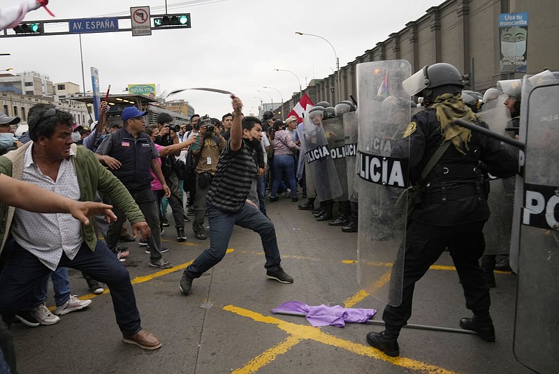 Supporters of former President Pedro Castillo confront riot police surrounding the police station Wednesday where Castillo arrived earlier in Lima, Peru.
(AP/Martin Mejia)
