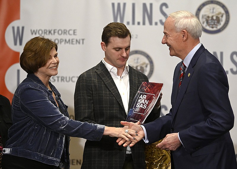 Gov. Asa Hutchinson shakes hands with state Rep. Charlene Fite, R-Van Buren as state Rep. Austin McCollum, R-Bentonville, holds a copy of a report by the Arkansas Council on Future Mobility during a news conference on Thursday.
(Arkansas Democrat-Gazette/Stephen Swofford)