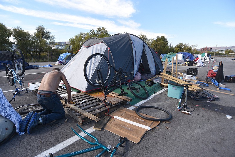 Staff photo by Matt Hamilton / Tents line an empty asphalt lot at the homeless camp at the intersection of 12th Street and Peeples Street on Friday, October 28, 2022.