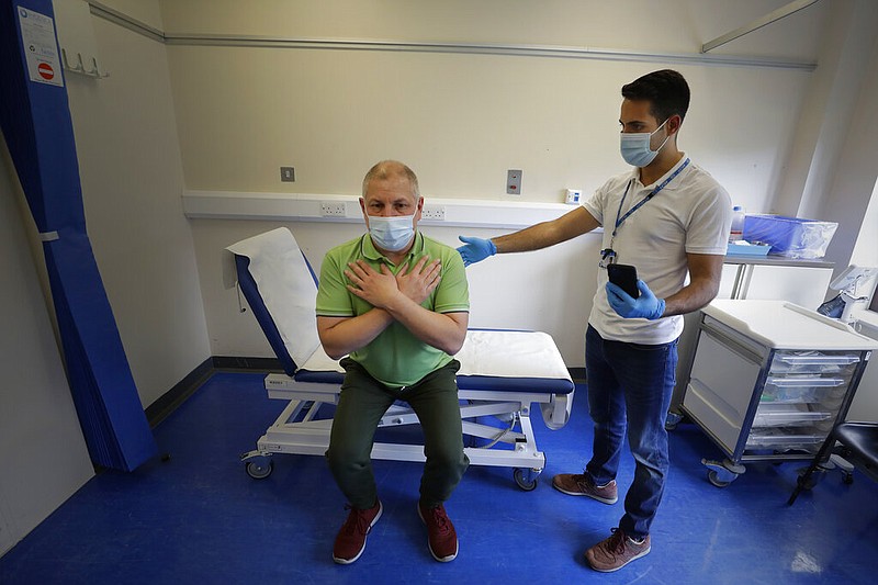 Long covid patient Gary Miller (left) receives treatment from physiotherapist Joan Del Arco at the Long COVID Clinic at King George Hospital in Ilford, London, in this May 11, 2021 file photo. The clinic has been set up to help patients suffering months after they were infected with covid-19. (AP/Kirsty Wigglesworth)