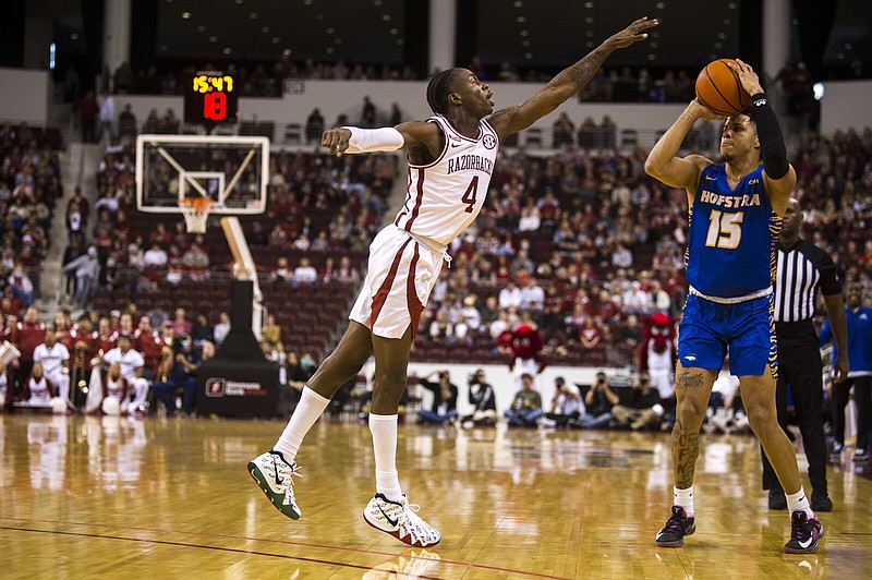Arkansas’ Davonte Davis defends a shot during the Razorbacks’ loss to Hofstra at Simmons Bank Arena in North Little Rock last season. The Hogs return to the arena Saturday to take on Bradley and the game will not be televised or streamed.
(Arkansas Democrat-Gazette/Stephen Swofford)