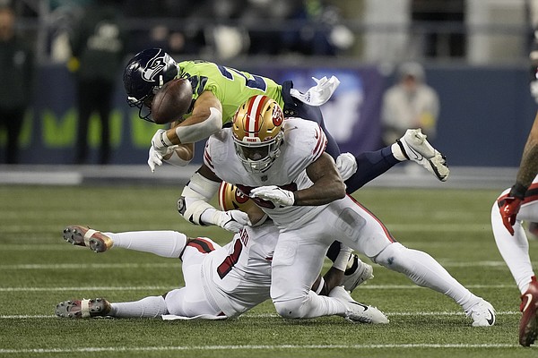 NFC cornerback Tariq Woolen (27) of the Seattle Seahawks tosses a signed  cleat to a fan