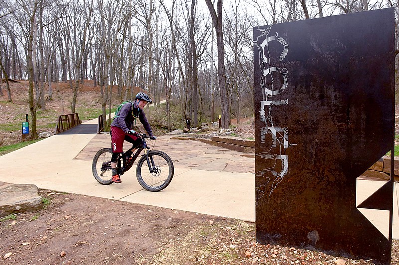 Damon Bourne of Madison, Wis., rides a hard-surface trail on Tuesday March 23 2021 after pedaling the soft-surface mountain bike trails at Coler Preserve in Bentonville. (NWA Democrat-Gazette/Flip Putthoff)