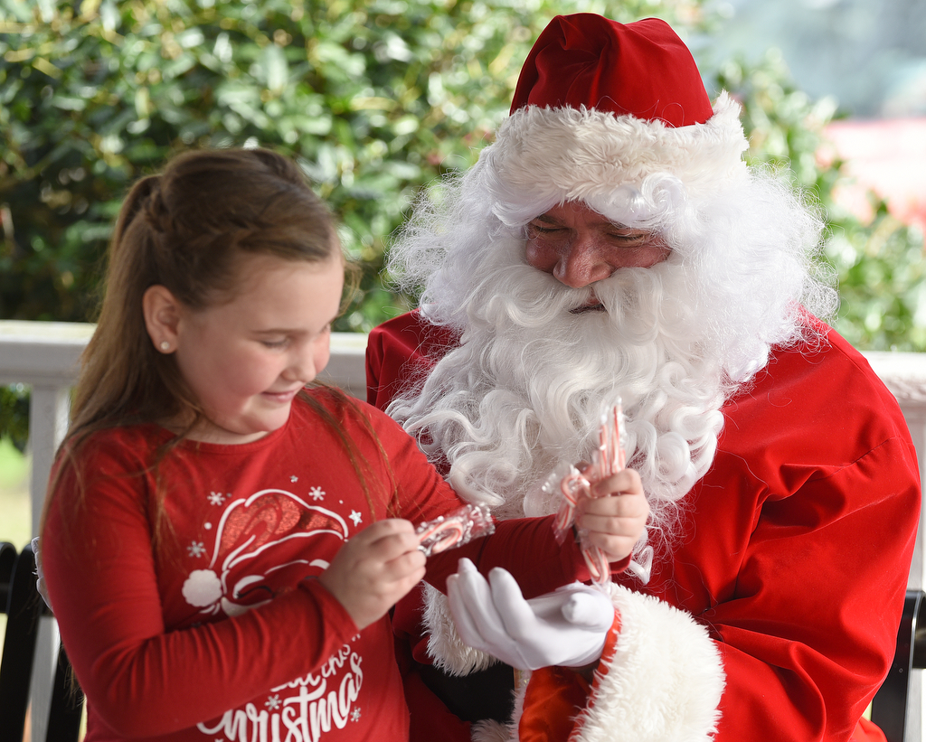 Staff photo by Matt Hamilton / Paislee Wright, 7, of LaFayette, accepts a handful of candy canes from Santa at Joe Stock Memorial Park in LaFayette, Ga. on Saturday, December 17, 2022. The cookies with Santa event was held as a fundraiser for Bridge Health, a community service board that offers adult programs, youth programs, programs for developmentally disabled and more.