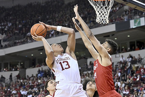 Arkansas guard Jordan Walsh (13) shoots over Bradley forward Malevy Leons during the first half of an NCAA college basketball game, Saturday, Dec. 17, 2022, in North Little Rock. (AP Photo/Michael Woods)