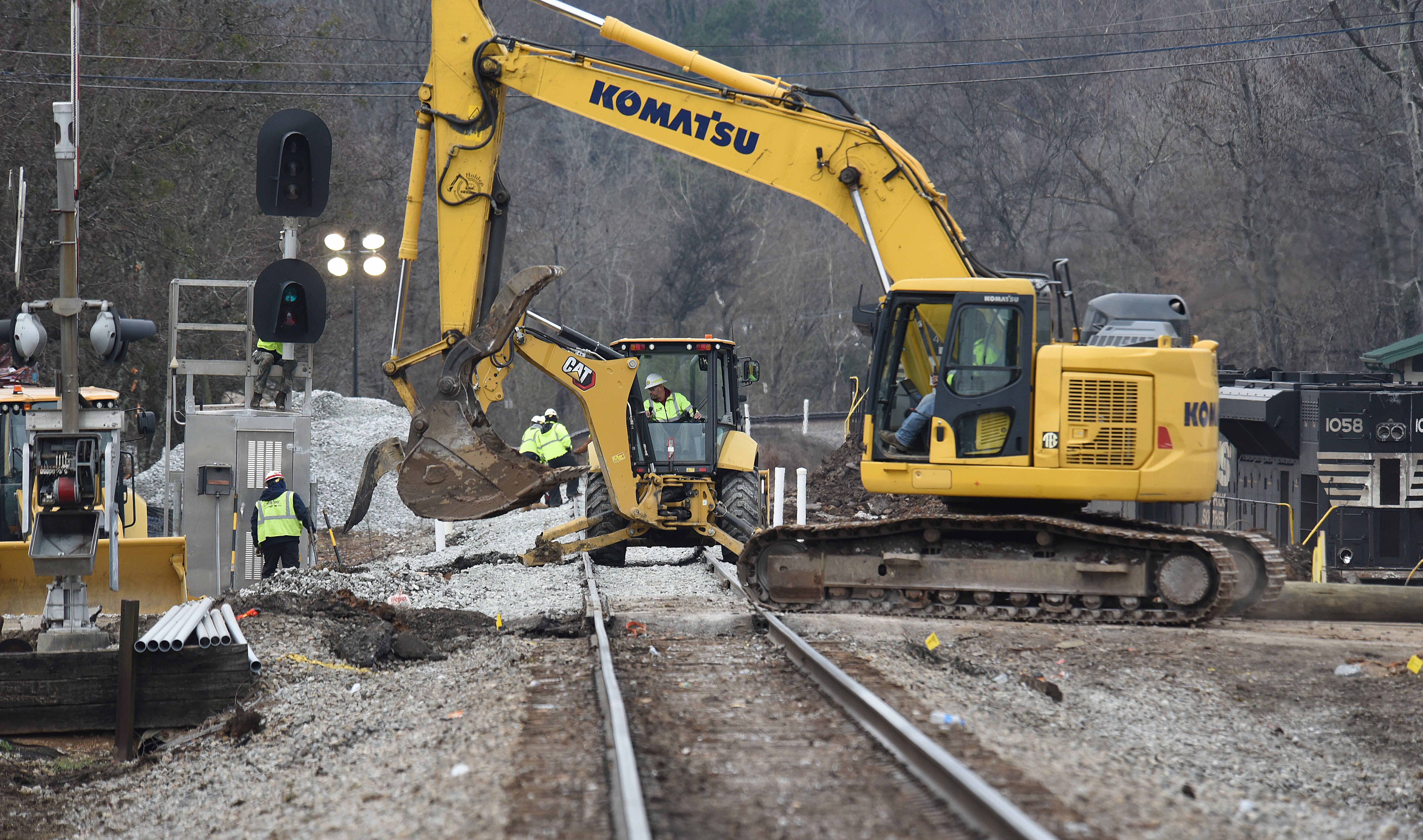 Staff photo by Matt Hamilton / A excavator cross the tracks as workers repair the tracks at the site of the train derailment at the intersection of the tracks with Apison Pike on Wednesday, December 21, 2022.