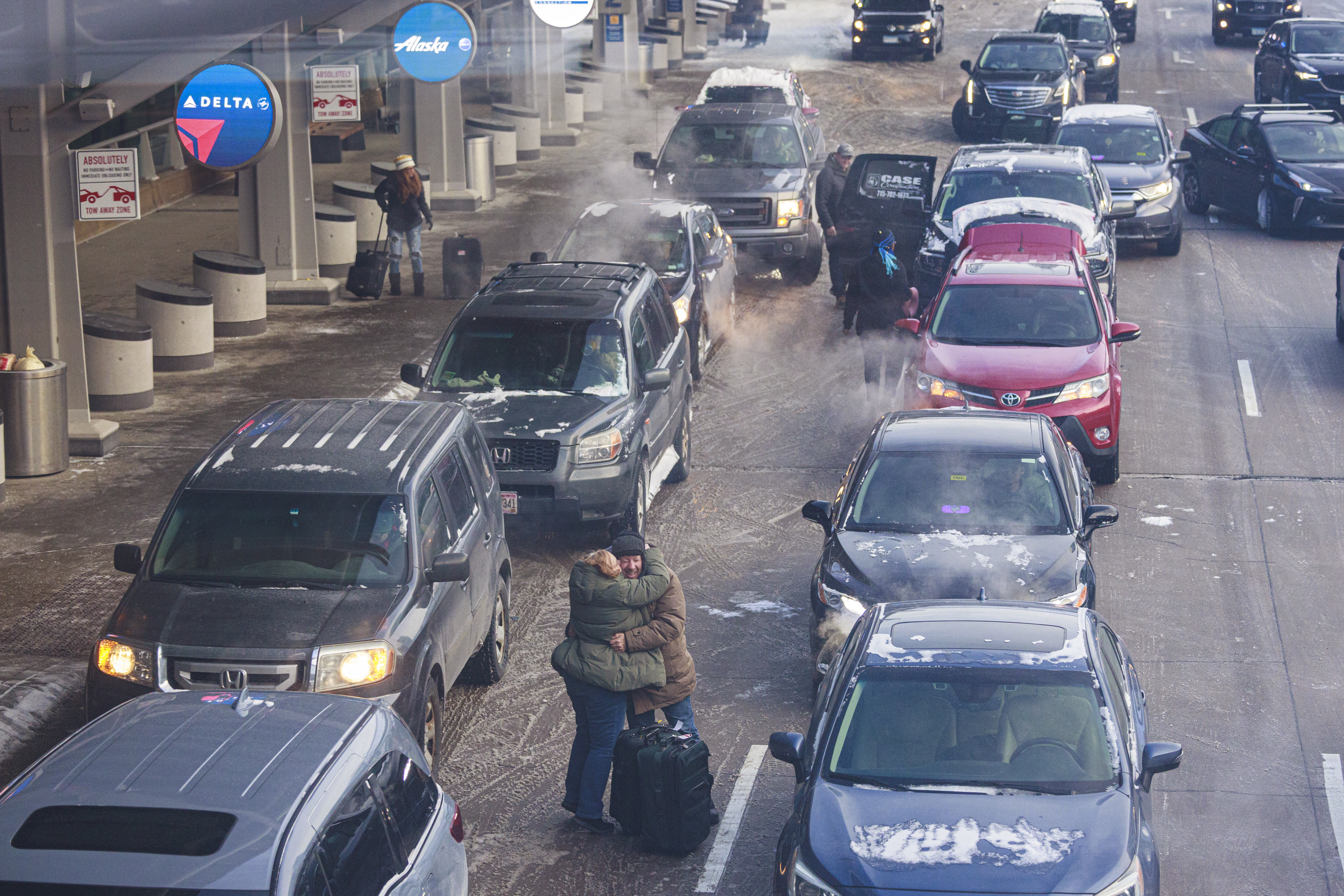Travelers unload from cars Thursday, Dec. 22, 2022 at Terminal 1 of the Minneapolis-Saint Paul International Airport in Minneapolis. (Kerem Yücel/Minnesota Public Radio via AP)