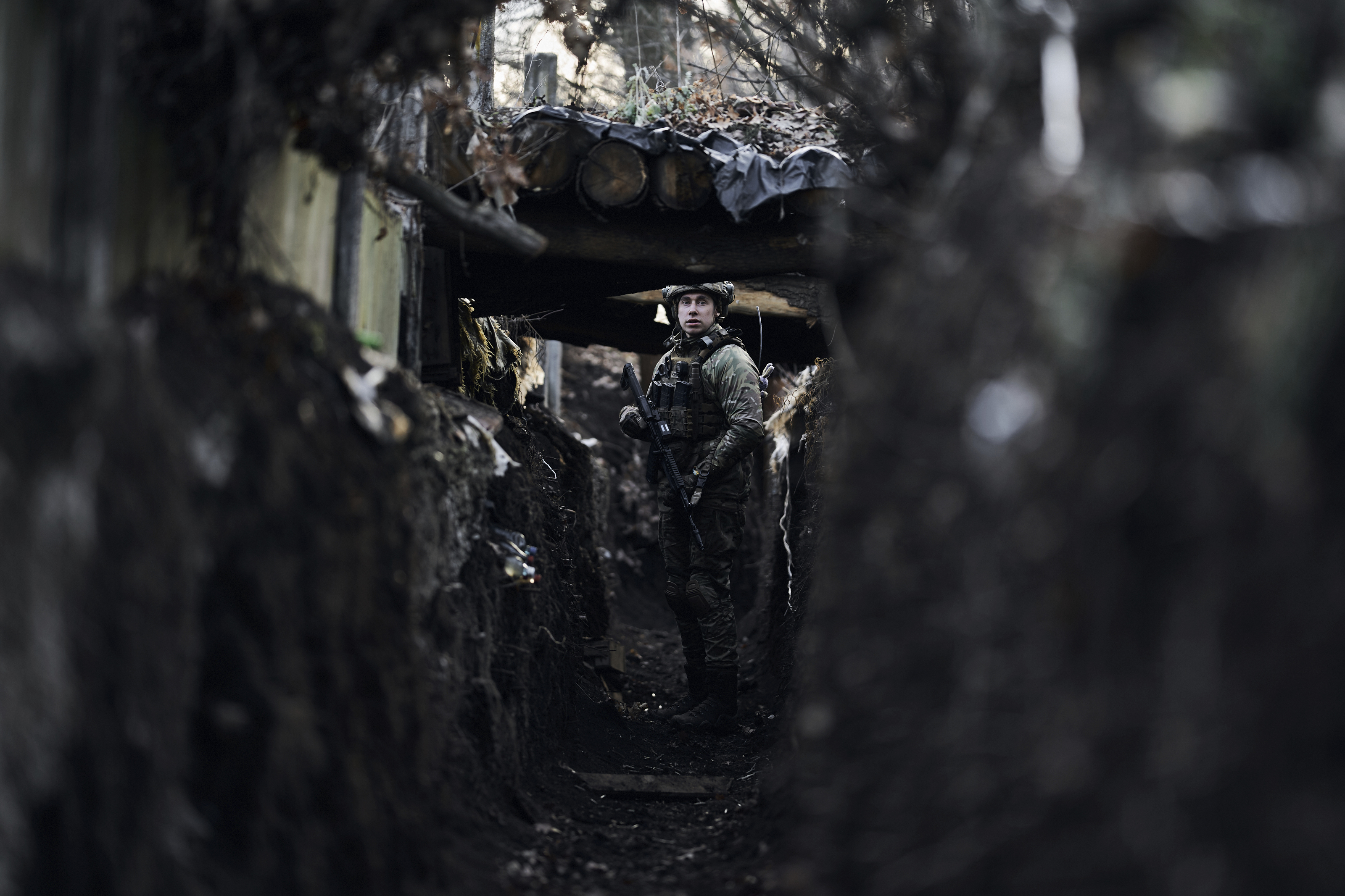 A Ukrainian soldier stands in a trench at a frontline position near Maryinka, Donetsk region, Ukraine, Friday, Dec. 23, 2022. (AP Photo/Libkos)