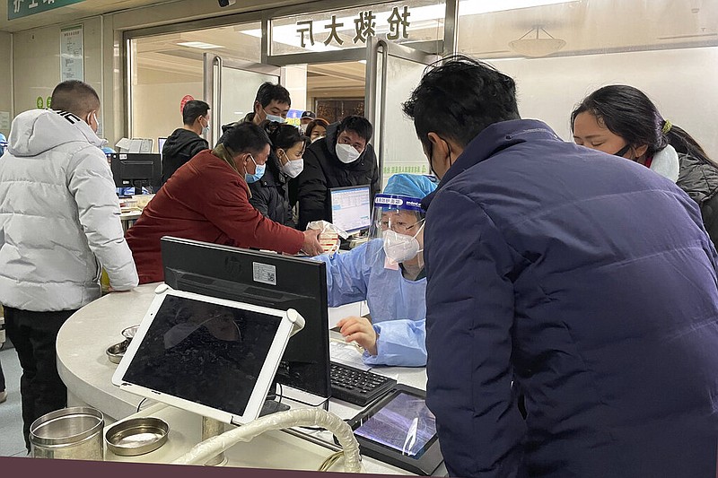 A worker in protective gear attends to visitors at the emergency department of the Langfang No. 4 People's Hospital in Bazhou city in northern China's Hebei province on Thursday, Dec. 22, 2022. (AP)