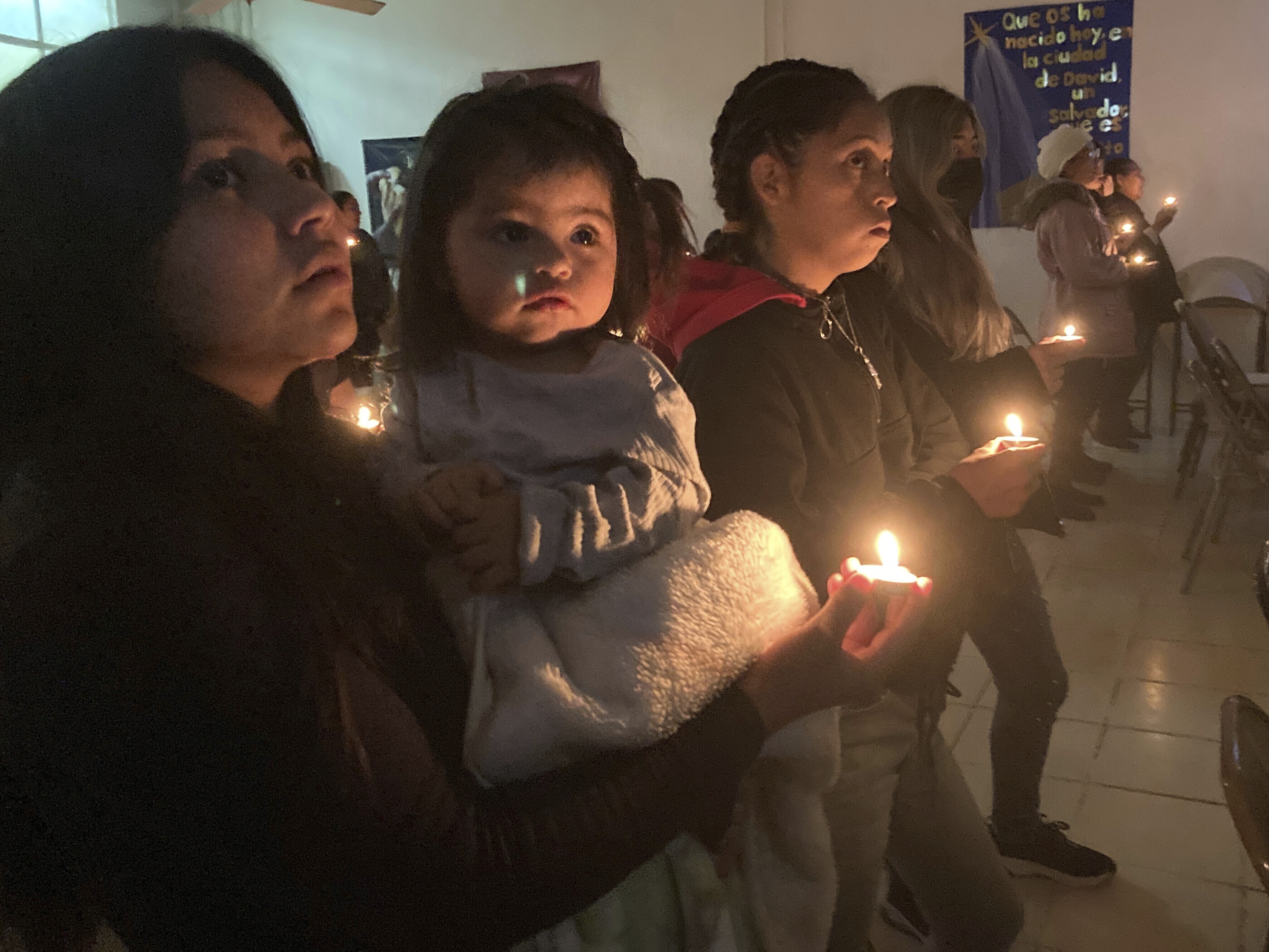 Guests at the Buen Samaritano shelter for migrants participate in a candle lighting ceremony in anticipation of Christmas in Ciudad Juárez, Mexico, across from El Paso, Texas, on Thursday, Dec. 22, 2022. Tens of thousands of migrants who fled violence and poverty will spend Christmas in crowded shelters or on the dangerous streets of Mexican border towns. The Biden administration asked the Supreme Court not to lift pandemic-era restrictions on asylum-seekers before the holiday weekend. (AP Photo/Morgan Lee)