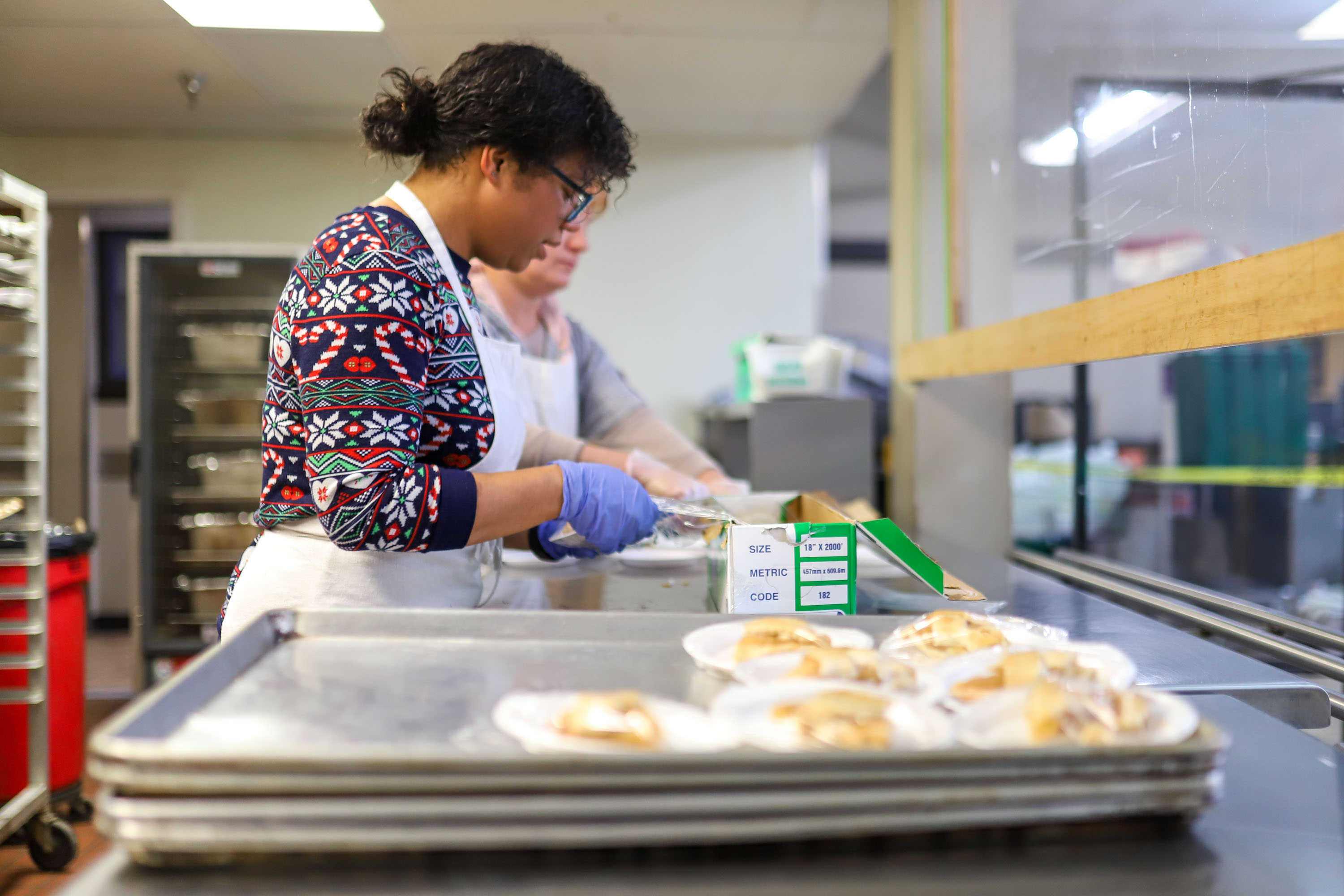 Staff photo by Olivia Ross  / Volunteers Lizz Johnson and Theresa Rogers plate slices of pie. The Community Kitchen held a Christmas Celebration with a holiday meal, Santa, and presents for all ages on Sunday, December 25, 2022.