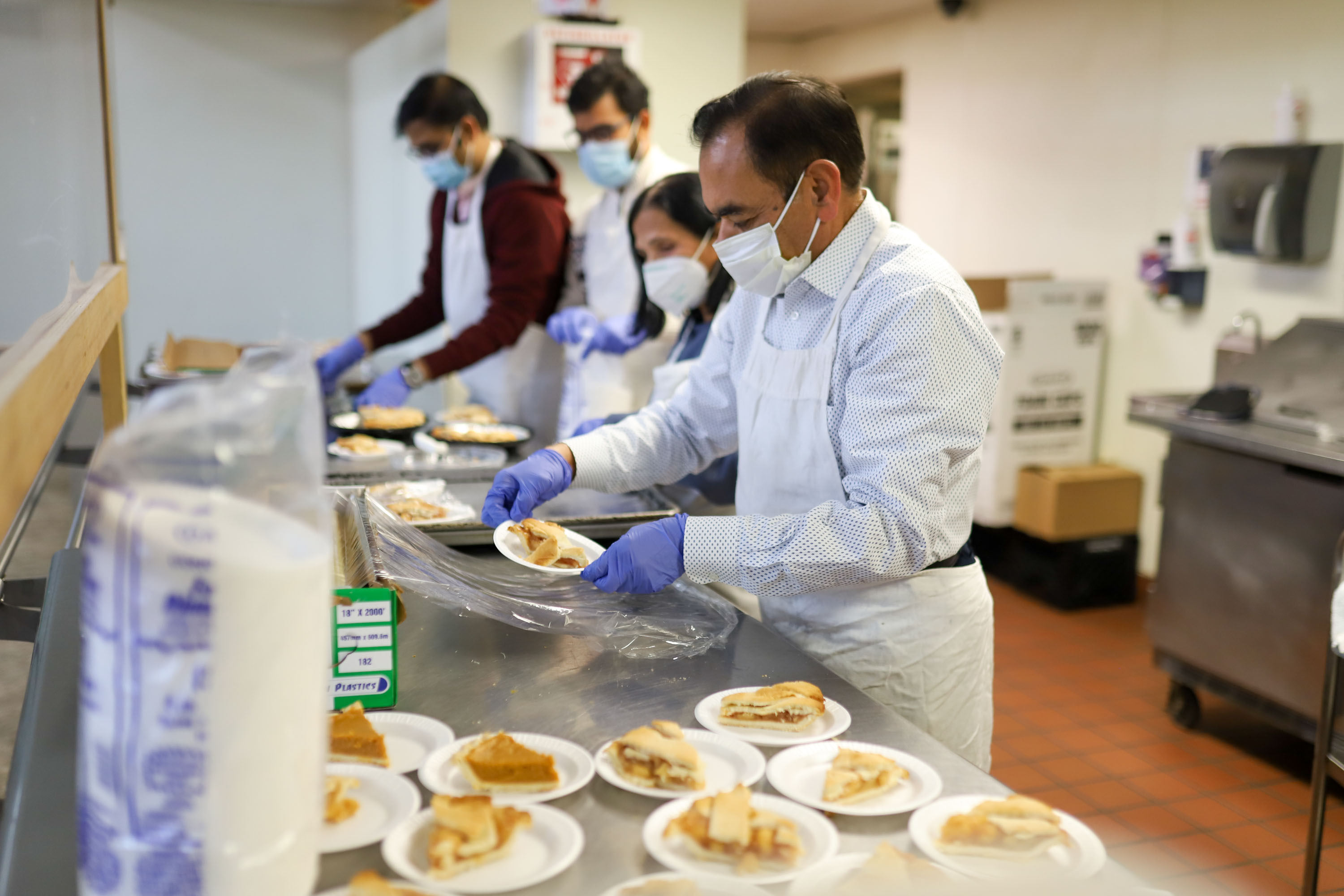 Staff photo by Olivia Ross  / Volunteers plate slices of pie. The Community Kitchen held a Christmas Celebration with a holiday meal, Santa, and presents for all ages on Sunday, December 25, 2022.