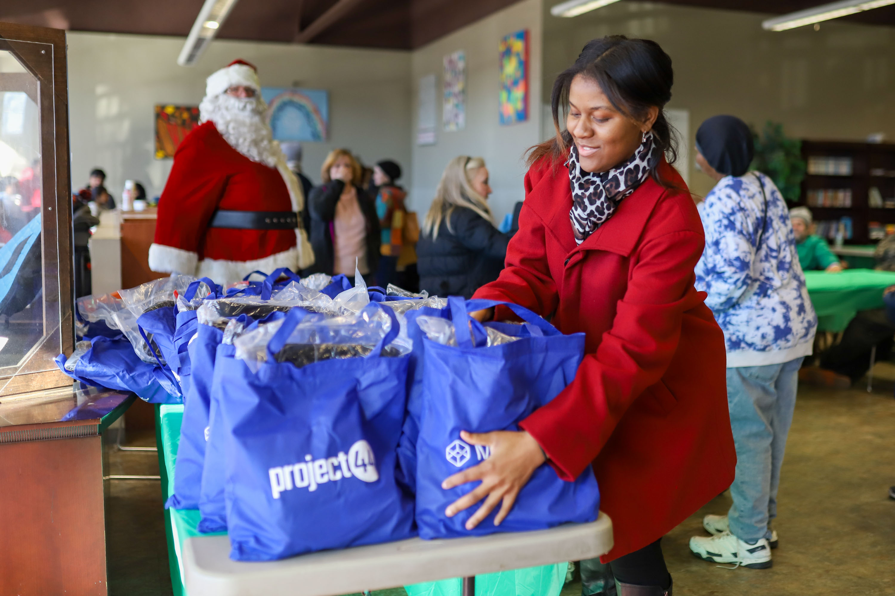 Staff photo by Olivia Ross  / Germyah Batey sets out presents. The Community Kitchen held a Christmas Celebration with a holiday meal, Santa, and presents for all ages on Sunday, December 25, 2022.
