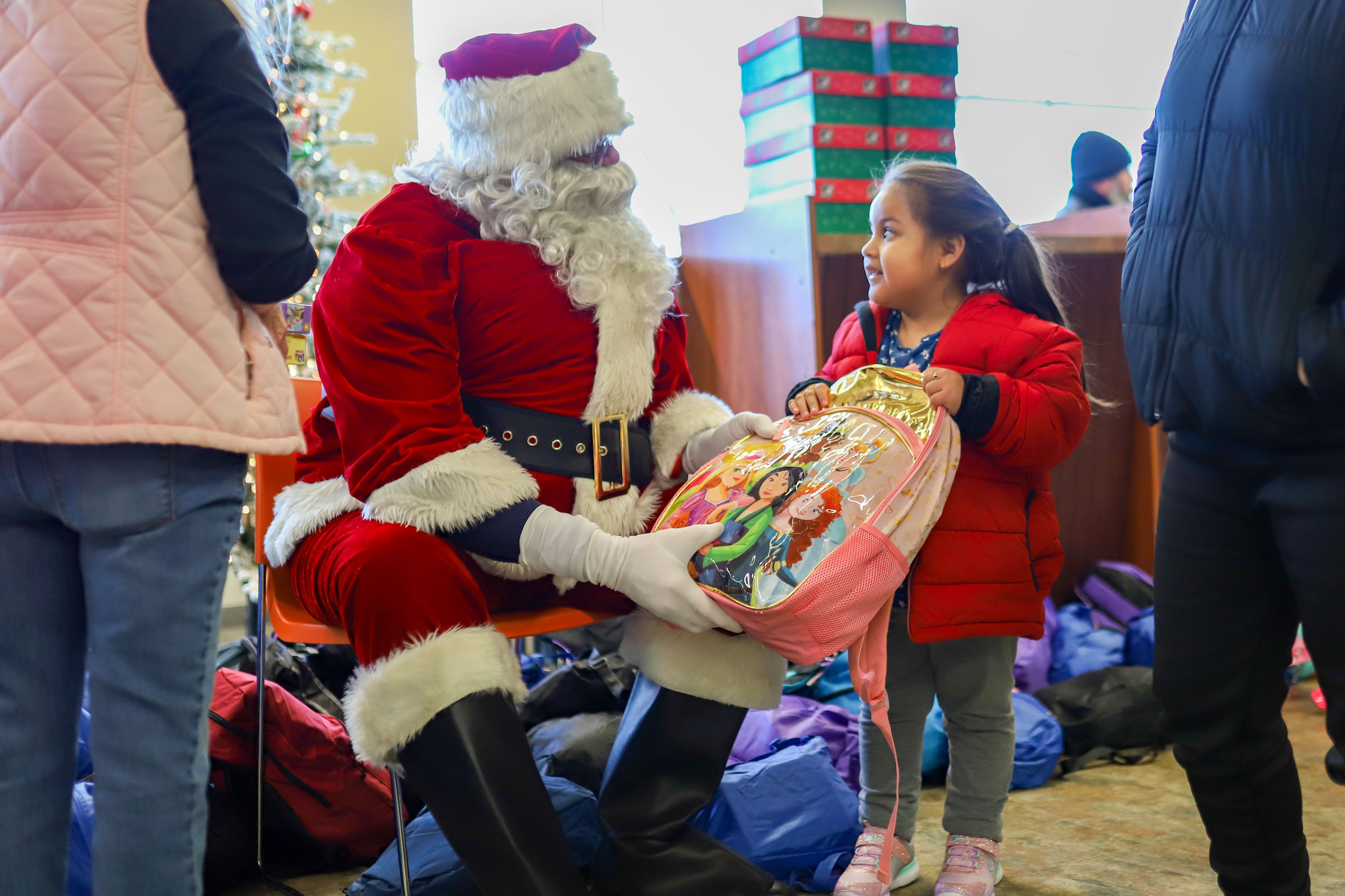 Staff photo by Olivia Ross  / Santa helps pass out presents. The Community Kitchen held a Christmas Celebration with a holiday meal, Santa, and presents for all ages on Sunday, December 25, 2022.