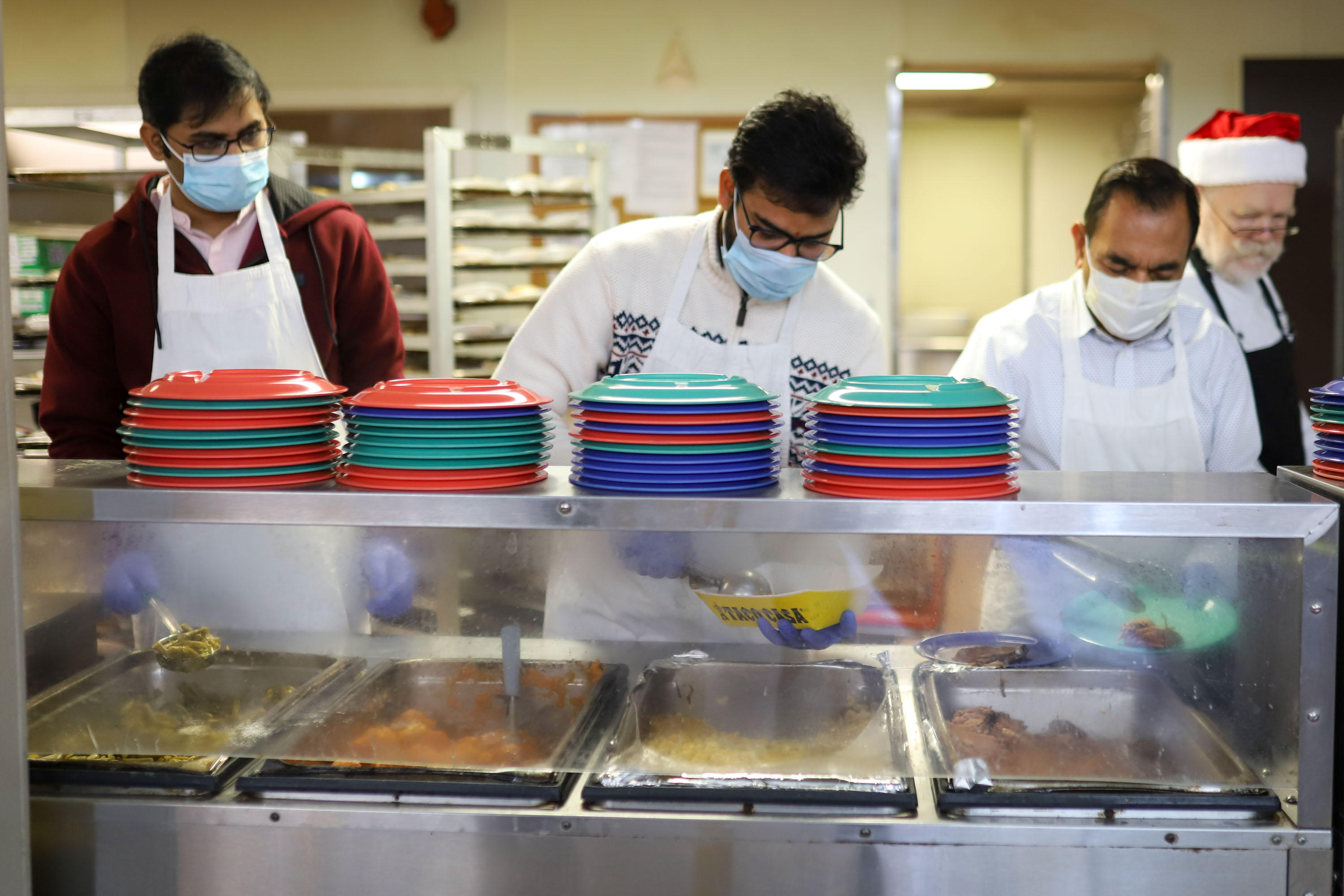 Staff photo by Olivia Ross  / Volunteers plate and serve meals to the guests. The Community Kitchen held a Christmas Celebration with a holiday meal, Santa, and presents for all ages on Sunday, December 25, 2022.