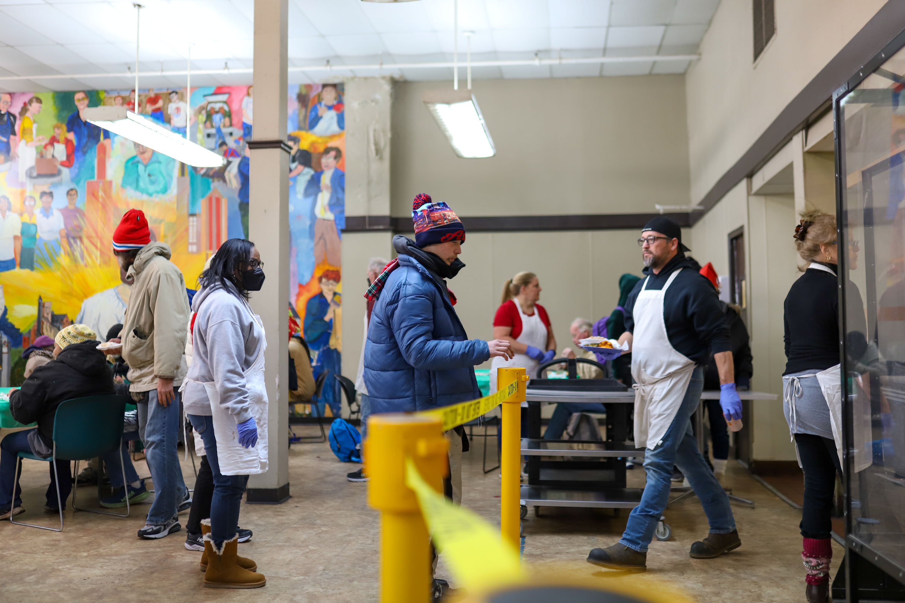 Staff photo by Olivia Ross  / Volunteers plate and serve meals to the guests. The Community Kitchen held a Christmas Celebration with a holiday meal, Santa, and presents for all ages on Sunday, December 25, 2022.