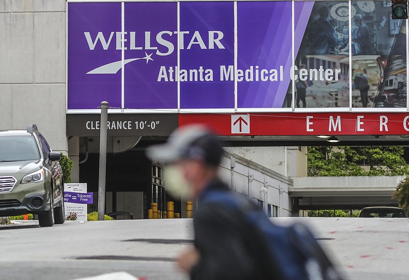 FILE - A masked man passes Wellstar Atlanta Medical Center in Atlanta on May 20, 2020, more than two years before the hospital was closed. (John Spink/Atlanta Journal-Constitution via AP)