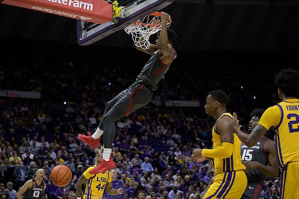 Arkansas guard Ricky Council (1) dunks next LSU forward KJ Williams (12) during the first half of an NCAA college basketball game in Baton Rouge, La., Wednesday, Dec. 28, 2022. (AP Photo/Matthew Hinton)