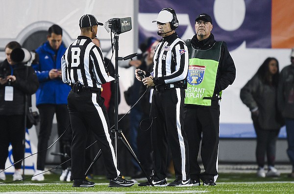 Pac-12 referee Matthew Richards (right) is shown during a video review during a the Liberty Bowl game between Arkansas and Kansas on Wednesday, Dec. 28, 2022, in Memphis, Tenn.