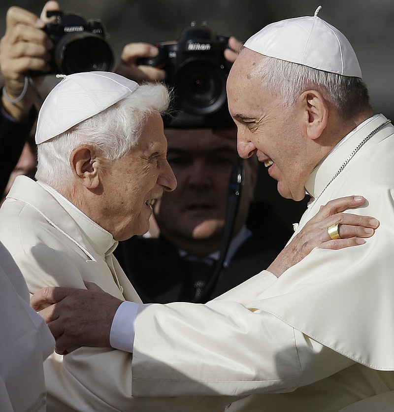 FILE - Pope Francis, right, hugs Pope Emeritus Benedict XVI prior to the start of a meeting with elderly faithful in St. Peter's Square at the Vatican, Sunday, Sept. 28, 2014. Pope Francis on Wednesday, Dec. 28, 2022, said his predecessor, Pope Emeritus Benedict XVI, is “very sick," and he asked the faithful to pray for the retired pontiff so God will comfort him “to the very end.” (AP Photo/Gregorio Borgia, File)