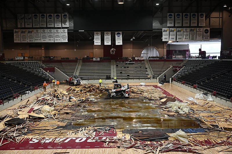 Crews clear wood flooring from the Jack Stephens Center in Little Rock on Wednesday. The floor was ruined as a result of ruptured fan coil inside the building’s air conditioning unit.
(Arkansas Democrat-Gazette/Stephen Swofford)