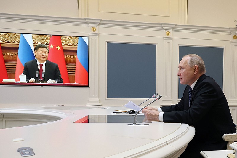 At the Kremlin, Russian President Vladimir Putin meets with Chinese President Xi Jinping, seen onscreen, in a video conference Friday. Putin said military cooperation has a “special place” in the relationship between their countries.
(AP/Sputnik/Mikhail Klimentyev)