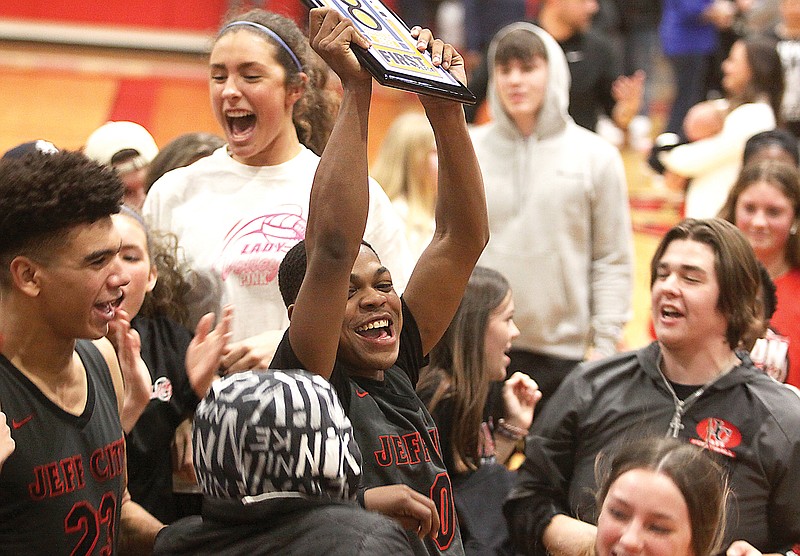 Jefferson City’s Judah Harris (center) holds up the first-place plaque as he celebrates with the Jays student section following Friday’s championship game against Fatima in the Joe Machens Great 8 Classic at Fleming Fieldhouse. (Greg Jackson/News Tribune)