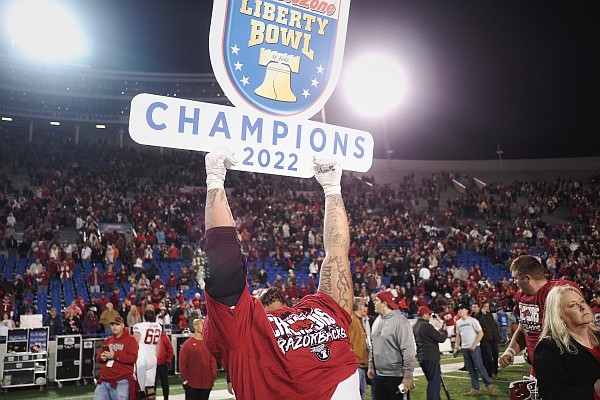 An Arkansas player holds up a sign, Wednesday, December 28, 2022 at the end of triple overtime during the Autozone Liberty Bowl at Simmons Bank Liberty Stadium in Memphis, Tenn. Visit nwaonline.com/photos for the photo gallery.