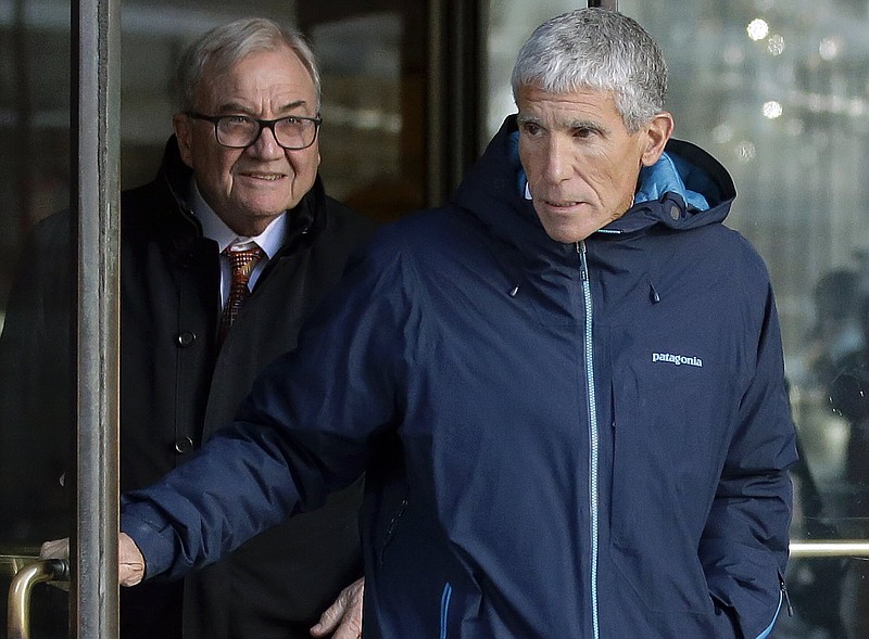 In this March 12, 2019 photo, William "Rick" Singer, front, founder of the Edge College & Career Network, exits federal court in Boston after he pleaded guilty to charges in a nationwide college admissions bribery scandal, where ringers were hired to take SAT tests and proctors paid to look the other way. 
(AP Photo/Steven Senne)