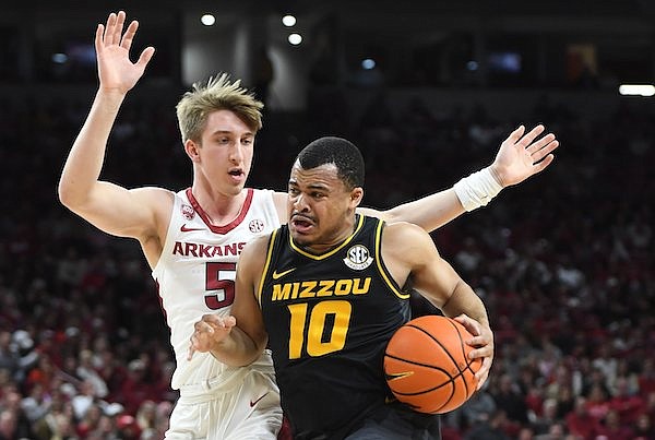 Arkansas guard Joseph Pinion (5) defends Wednesday, Jan. 4, 2023, as Missouri guard Nick Honor (10) drives to the lane during the first half of play in Bud Walton Arena in Fayetteville.