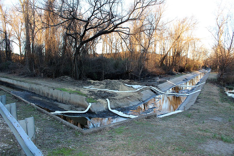 White piping could be seen Thursday across a concrete culvert, part of water cleanup efforts at the corner of South Walco Road and Kelly Street in Malvern.
(Arkansas Democrat-Gazette/Cristina LaRue)