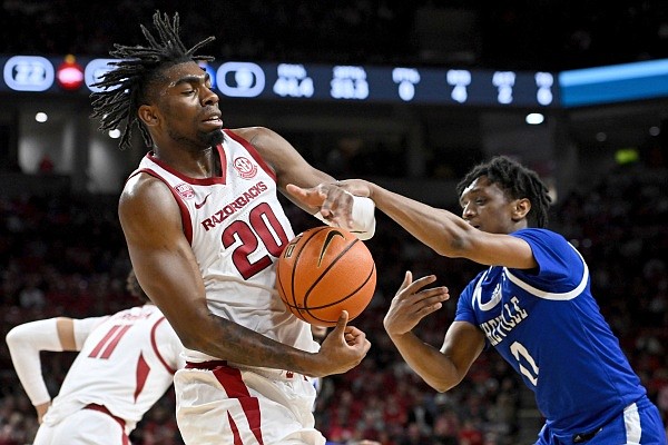 Arkansas forward Kamani Johnson (20) and UNC Asheville guard Trent Stephney (0) fight for a rebound during the first half of an NCAA college basketball game, Wednesday, Dec. 21, 2022, in Fayetteville, Ark. (AP Photo/Michael Woods)