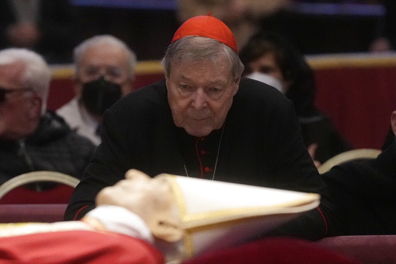 Australian Cardinal George Pell stands next to the body of late Pope Emeritus Benedict XVI lied out in state inside St. Peter's Basilica at The Vatican, Tuesday, Jan. 3, 2023. Pope Benedict, the German theologian who will be remembered as the first pope in 600 years to resign, has died, the Vatican announced Saturday, Dec. 31, 2022. He was 95. (AP Photo/Gregorio Borgia)