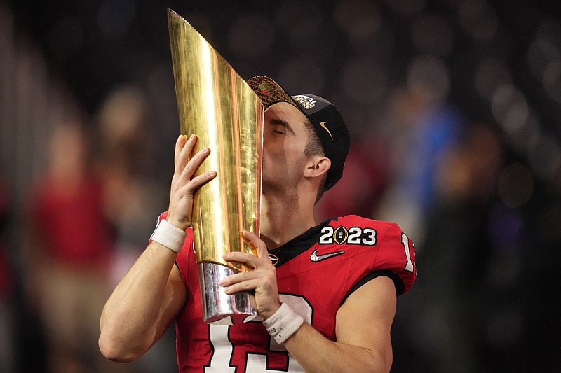 Georgia quarterback Stetson Bennett (13) kisses the championship trophy after the national championship NCAA College Football Playoff game against TCU, Monday, Jan. 9, 2023, in Inglewood, Calif. Georgia won 65-7. (AP Photo/Ashley Landis)