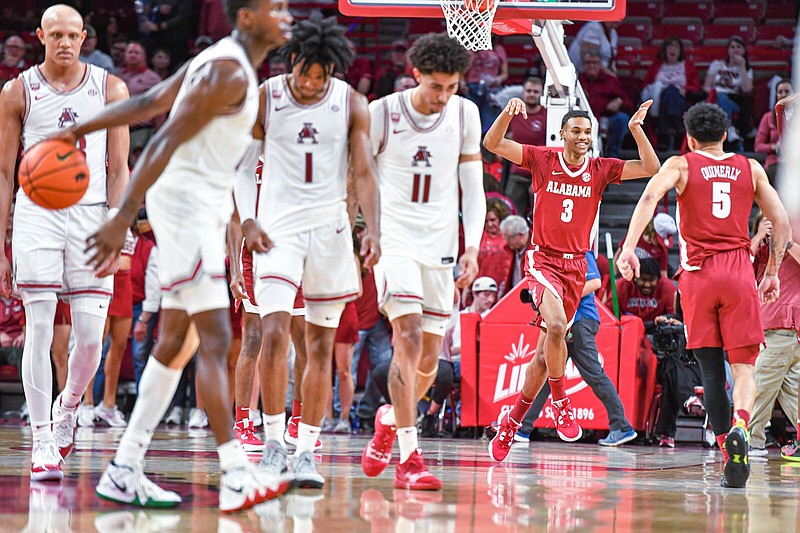 Arkansas players Jordan Walsh (from left), Davonte Davis, Ricky Council and Jalen Graham walk off the floor Wednesday, while Alabama guards Rylan Griffen and Jahvon Quinerly celebrate the No. 4 Crimson Tide’s 84-69 victory over the No. 15 Razorbacks at Walton Arena in Fayetteville. More photos at arkansasonline.com/112uaua/.
(NWA Democrat-Gazette/Hank Layton)