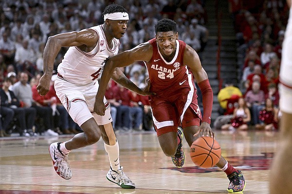 Alabama forward Brandon Miller (24) tries to get past Arkansas guard Davonte Davis (4) during the first half of an NCAA college basketball game Wednesday, Jan. 11, 2023, in Fayetteville. (AP Photo/Michael Woods)