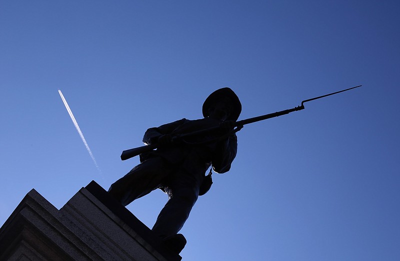 An airplane contrail and a clear blue sky form a backdrop for "Memorial to Company A, Capital Guards," a Confederate statue on the grounds of MacArthur Park in Little Rock, in this Jan. 14, 2016 file photo. (Arkansas Democrat-Gazette/John Sykes Jr.)