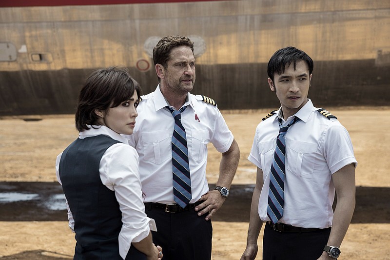 After a forced landing in a war zone, beleaguered flight crew members Bonnie (Daniella Pineda), Brodie (Gerard Butler) and Dele (Yoson An) discuss their options in “Plane.”