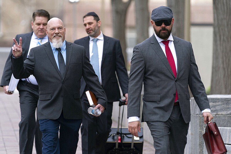 Richard "Bigo" Barnett (left) arrives at federal court in Washington in this Tuesday, Jan. 10, 2023 file photo. At right is Barnett's attorney, Joseph McBride, while at back left is another of his attorneys, Bradford Geyer. Barnett was photographed with his feet up on a desk in the office of then-House Speaker Nancy Pelosi during the Jan. 6 riot at the Capitol. (AP/Jose Luis Magana)