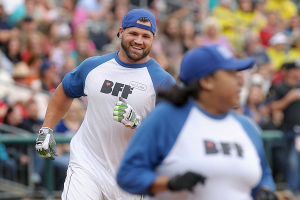 Former Arkansas and NFL running back Peyton Hillis runs the bases while playing in the second annual "A League of Their Own" reunion softball game on Sunday, May 8, 2016, at Arvest Ballpark in Springdale.