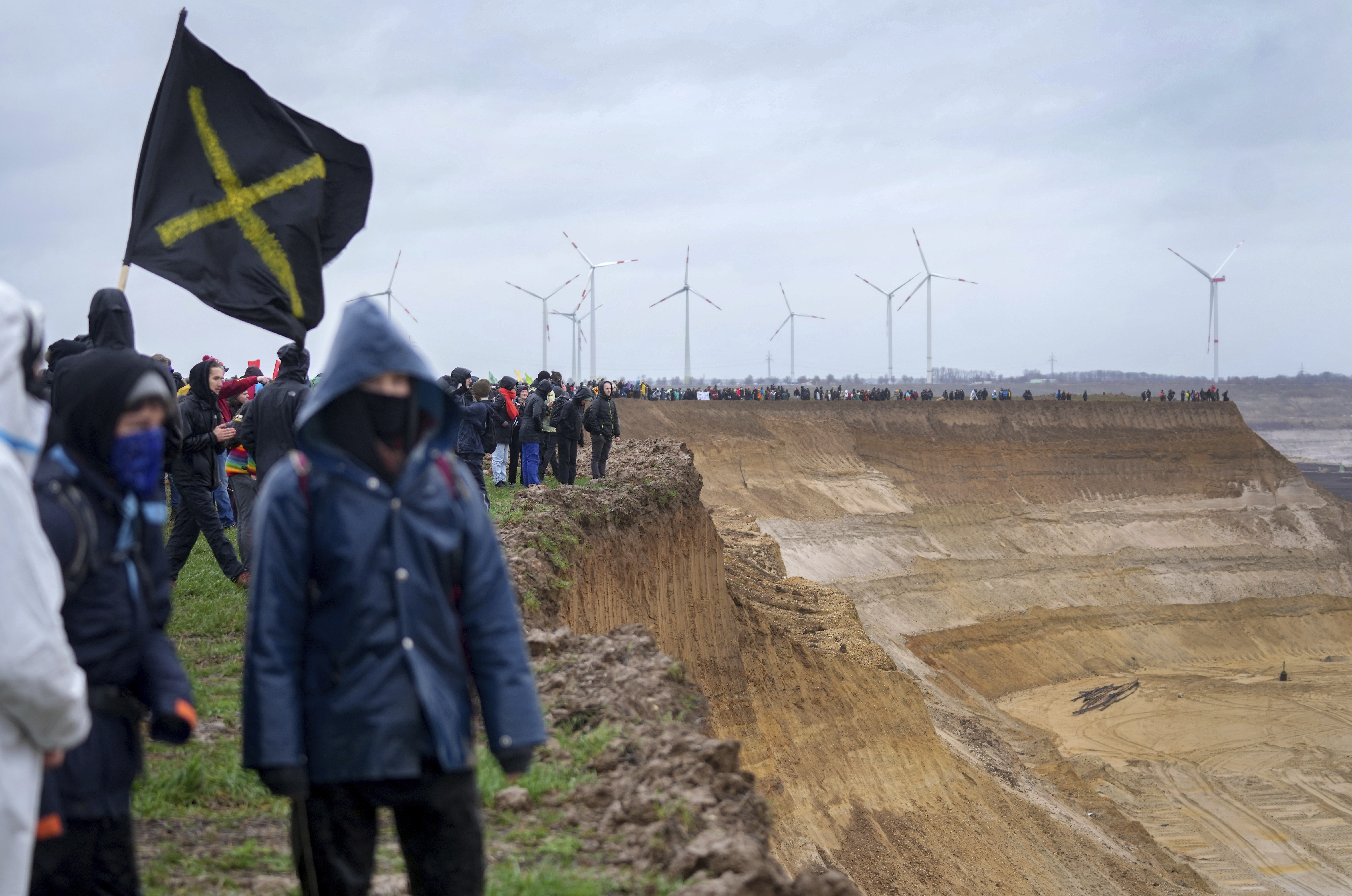 People attend a protest rally at the Garzweiler opencast mining near the village Luetzerath in Erkelenz, Germany, Saturday, Jan. 14, 2023. Swedish climate campaigner Greta Thunberg takes part in that protest rally after she visited the tiny village of Luetzerath on Friday and took a look at the nearby Garzweiler open coal mine. (AP Photo/Michael Probst)