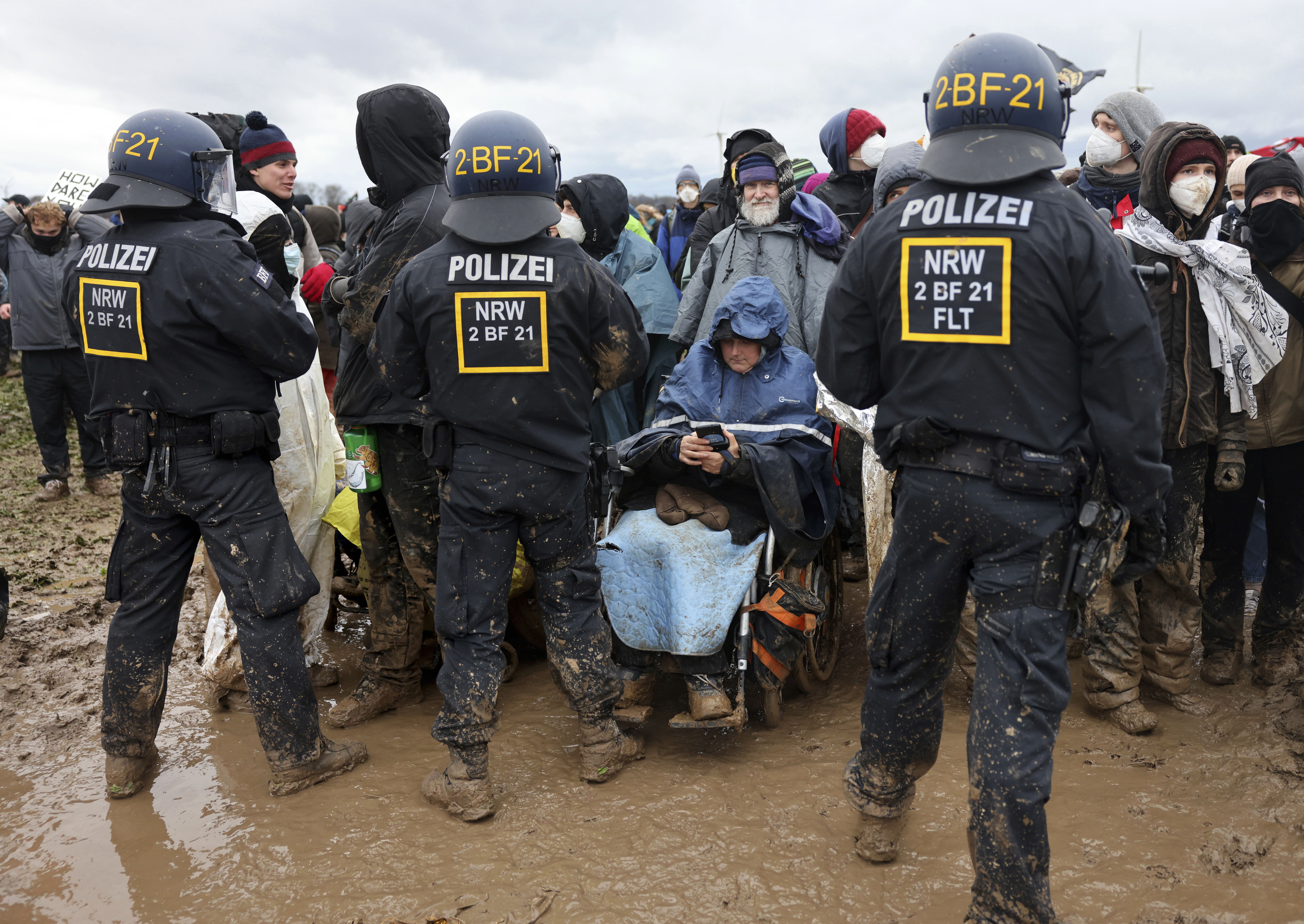 A demonstrator in a wheelchair takes part in a protest near the opencast lignite mine Garzweiler, in the village Luetzerath near Erkelenz, Germany, Saturday, Jan. 14, 2023. Thousands of people demonstrated in persistent rain on Saturday to protest the clearance and demolition of a village in western Germany that is due to make way for the expansion of a coal mine. (Oliver Berg/dpa via AP)