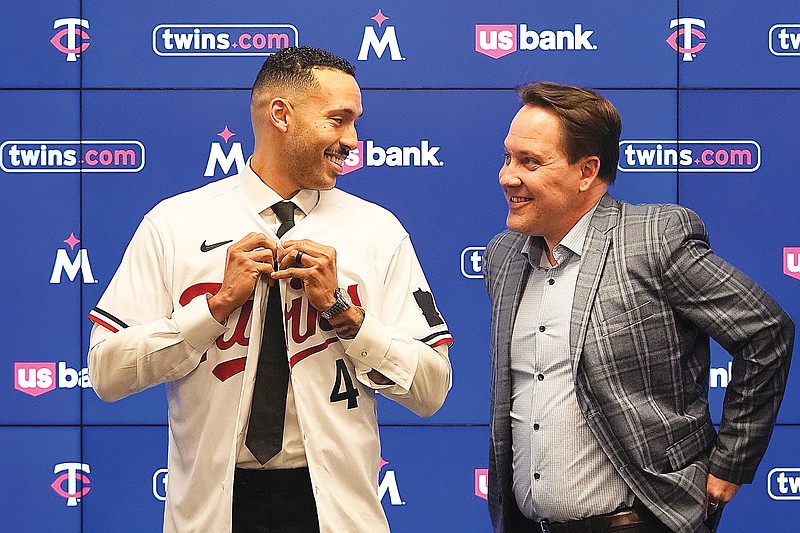 Carlos Correa puts on a jersey last Wednesday alongside Twins president of baseball operations Derek Falvey in Minneapolis. (Associated Press)