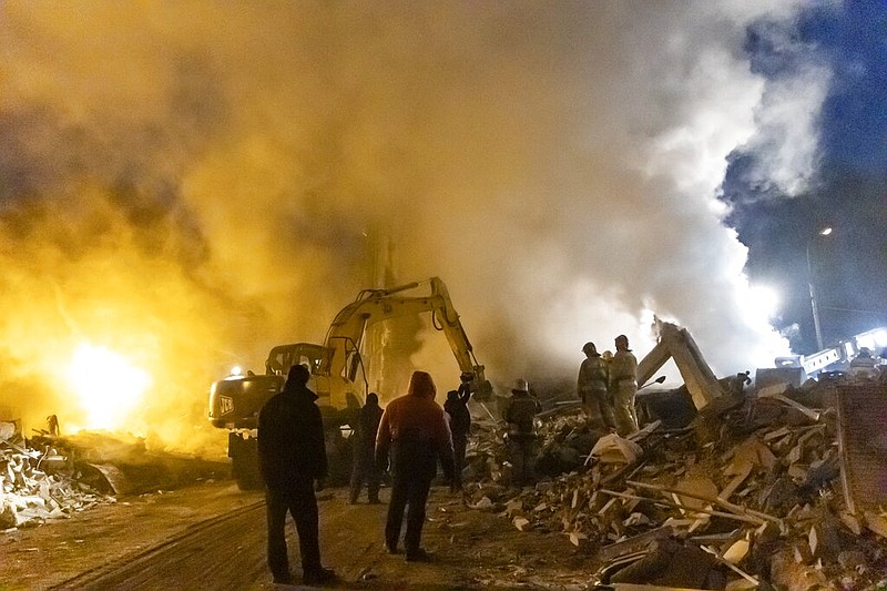 Smoke rises as Donetsk's emergency employees work at a site of a shopping center destroyed following what Russian officials in Donetsk said it was a shelling by Ukrainian forces, in Donetsk, in Russian-controlled Donetsk region, eastern Ukraine, Monday, Jan. 16, 2023. (AP Photo/Alexei Alexandrov)