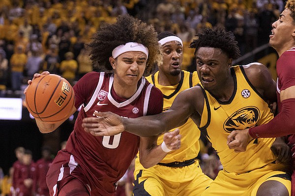 Arkansas' Anthony Black, left, dribbles past Missouri's Kobe Brown, right, during the first half of an NCAA college basketball game Wednesday, Jan. 18, 2023, in Columbia, Mo. (AP Photo/L.G. Patterson)