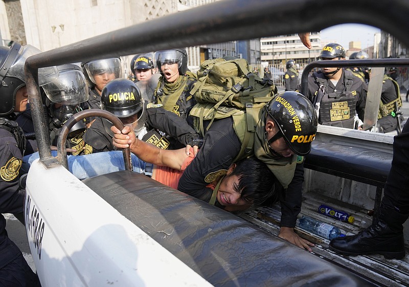 An anti-government protester who traveled to the capital to march against Peruvian President Dina Boluarte is detained and thrown on the back of a police vehicle during clashes Thursday in Lima, Peru.
(AP/Martin Mejia)